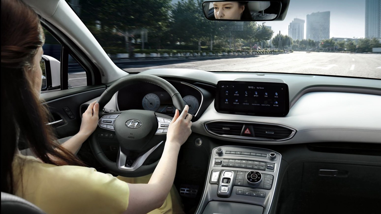 Kvindelig fører kører Hyundai SANTA FE Plug-in Hybrid i by