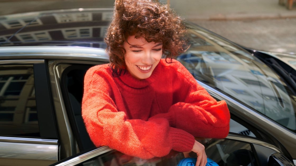 Hyundai bluelink glad kvinde stående ved bildør
