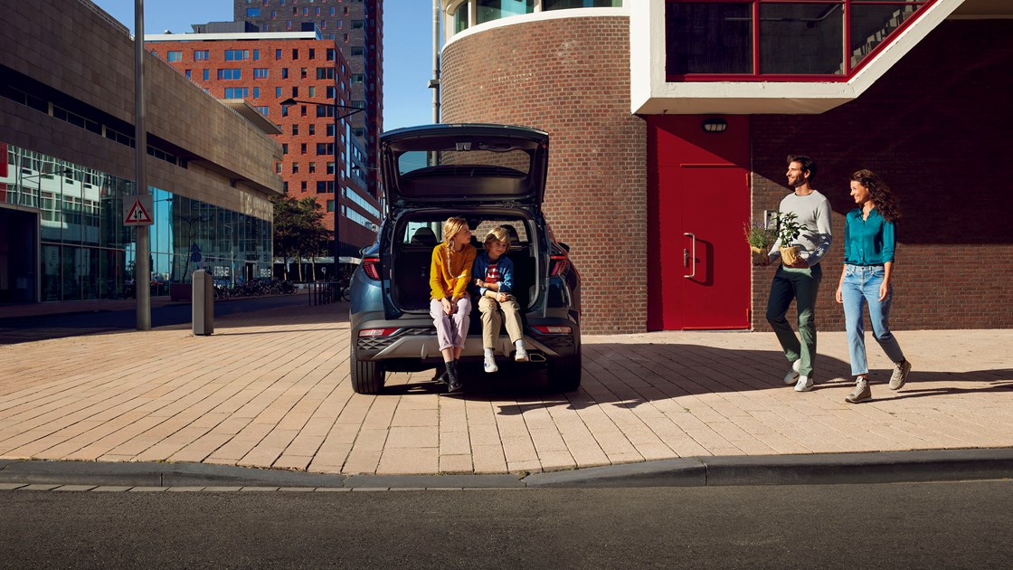 Børn venter i åbent bagagerum på  Hyundai TUCSON Plug-in Hybrid 