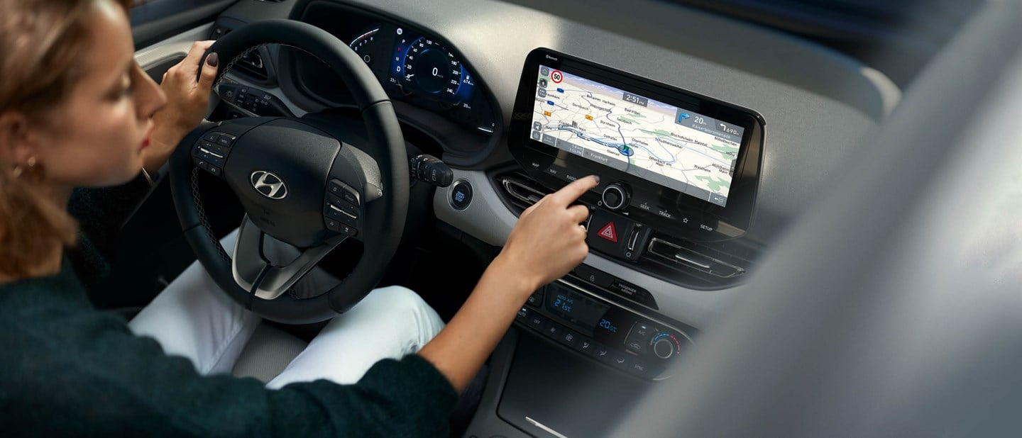 Kvindelig Hyundai-ejer benytter navigationen i sin Hyundai