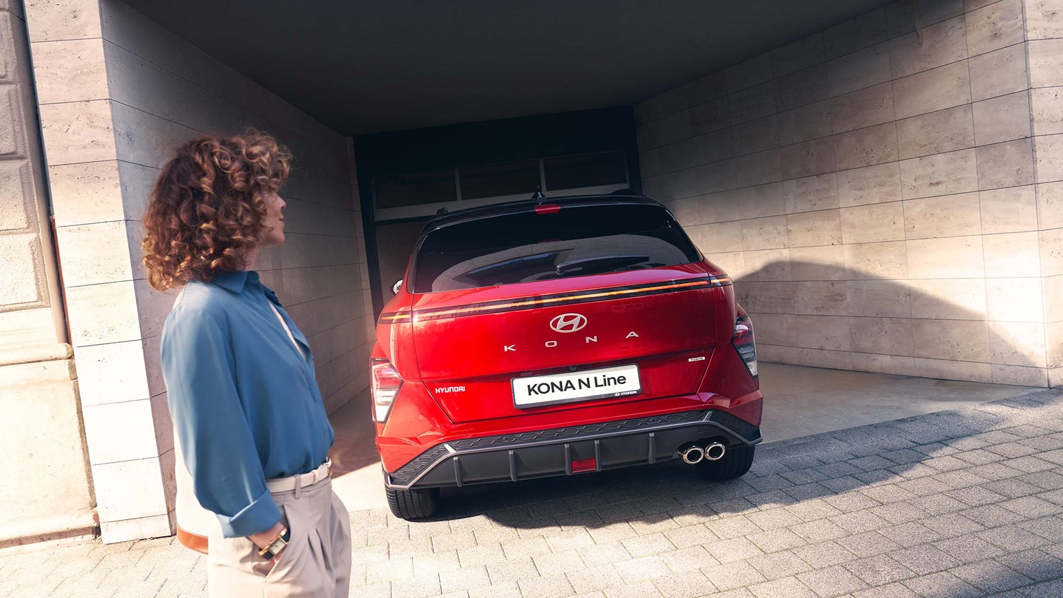 Kvinde kigger på rød Hyundai KONA N Line parkeret
