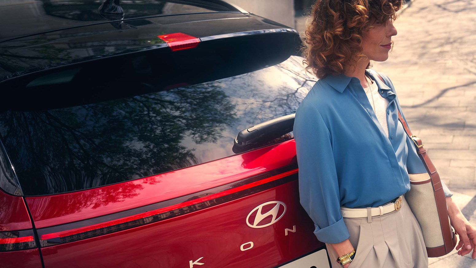 Kvinde læner sig op af rød Hyundai KONA N Line