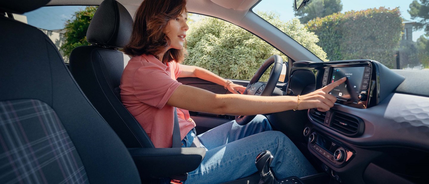 Kvindelig fører af Hyundai i10 benytter touchskærm