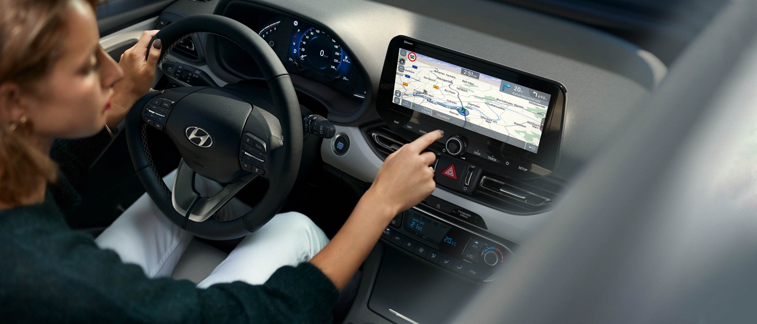 Kvinde køre i sin Hyundai og trykker på touchskæm GPS 