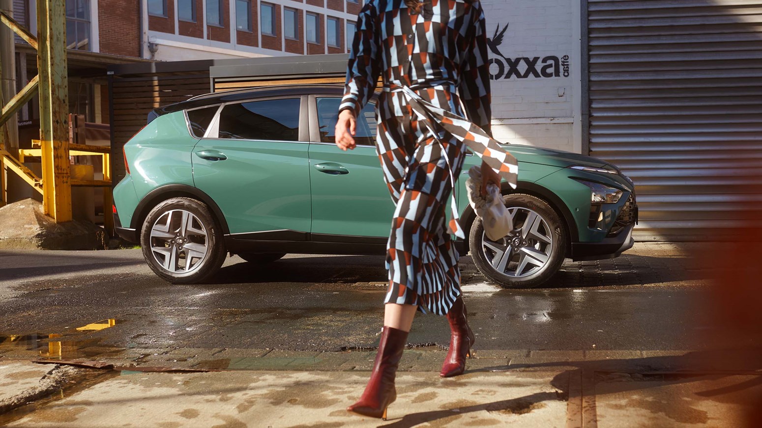Kvinde går væk fra Hyundai BAYON parkeret i urban miljø