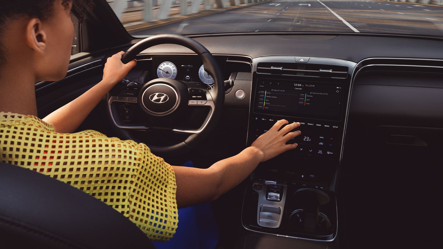 Kvindelig fører benytter touchskærm og digital instrumentering i Hyundai TUCSON 